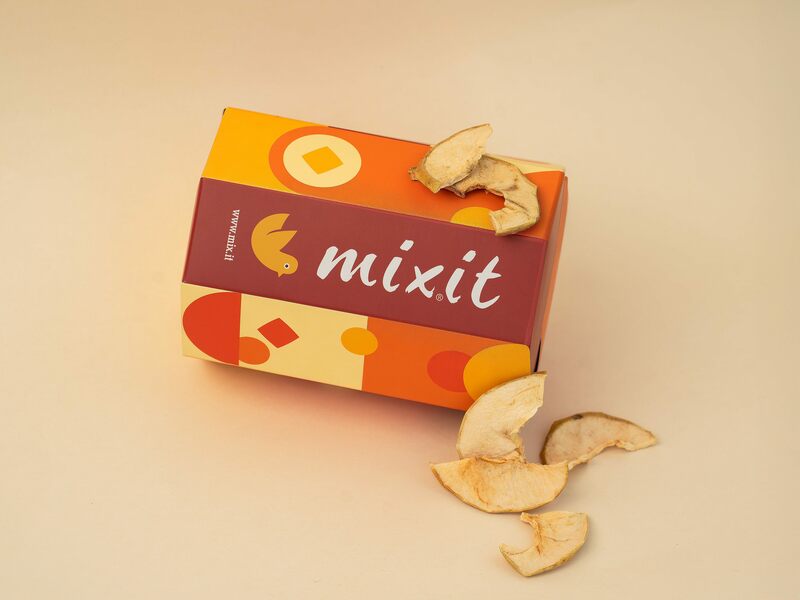 Chipsuri de mere, felii de mere lângă un tub octogon colorat Mixit.
